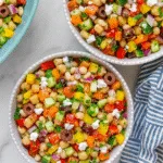 Seasonal dense bean salad with chickpeas, roasted vegetables, and herbs in a rustic ceramic bowl