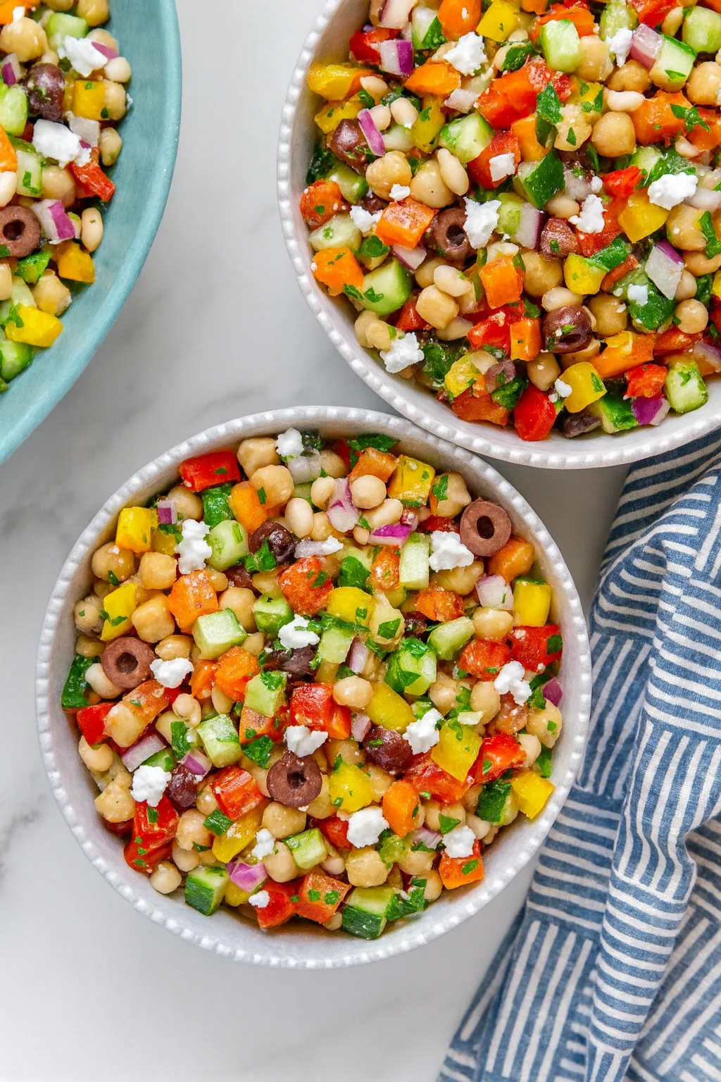 Seasonal dense bean salad with chickpeas, roasted vegetables, and herbs in a rustic ceramic bowl